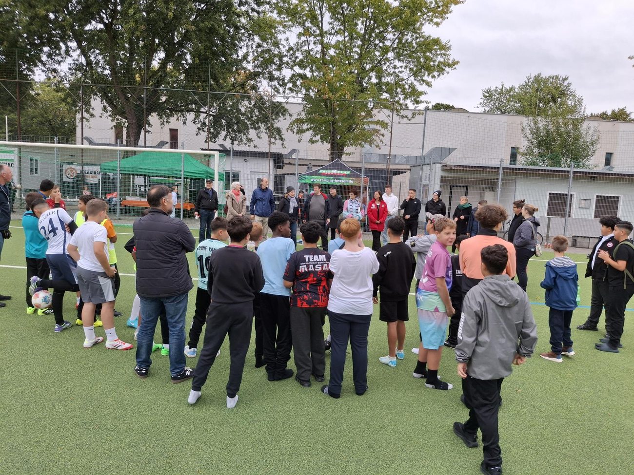 Menschen beim „Kicken für die Demokratie“ auf dem Sportplatz